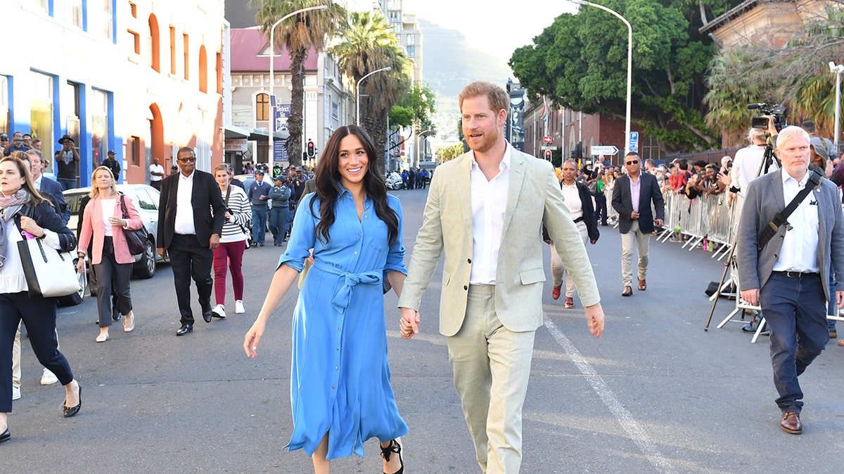 Prince Harry and Meghan Markle walking together outdoors
