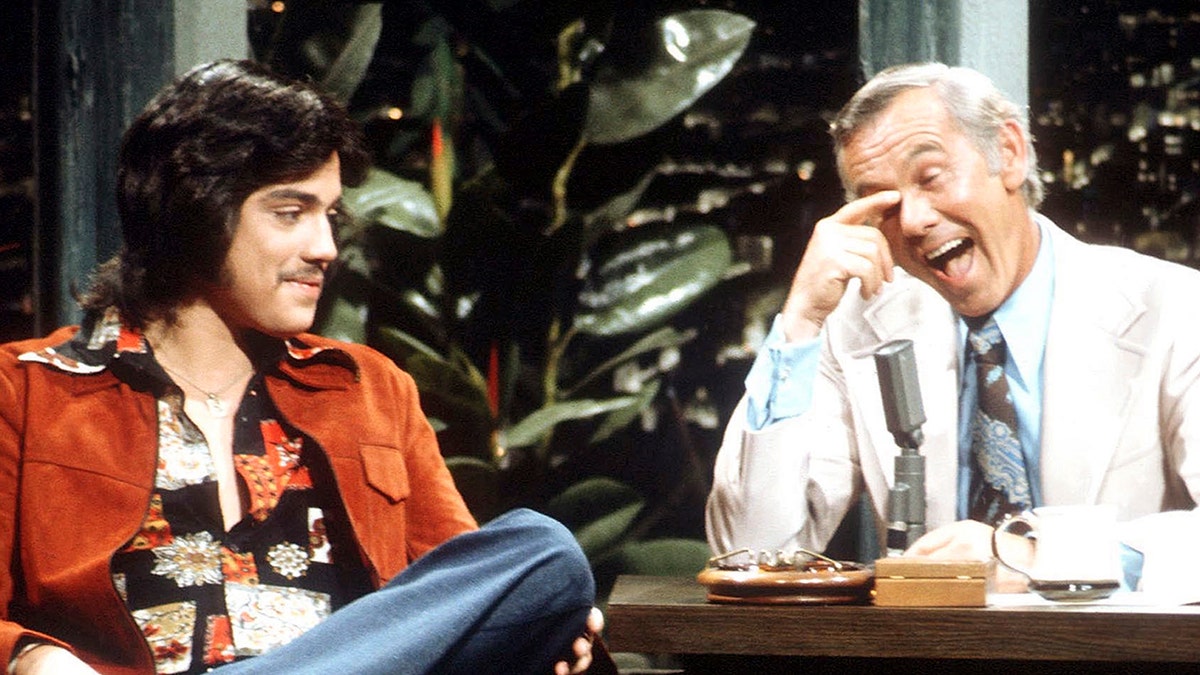 Freddie Prinze sitting next to a laughing Johnny Carson