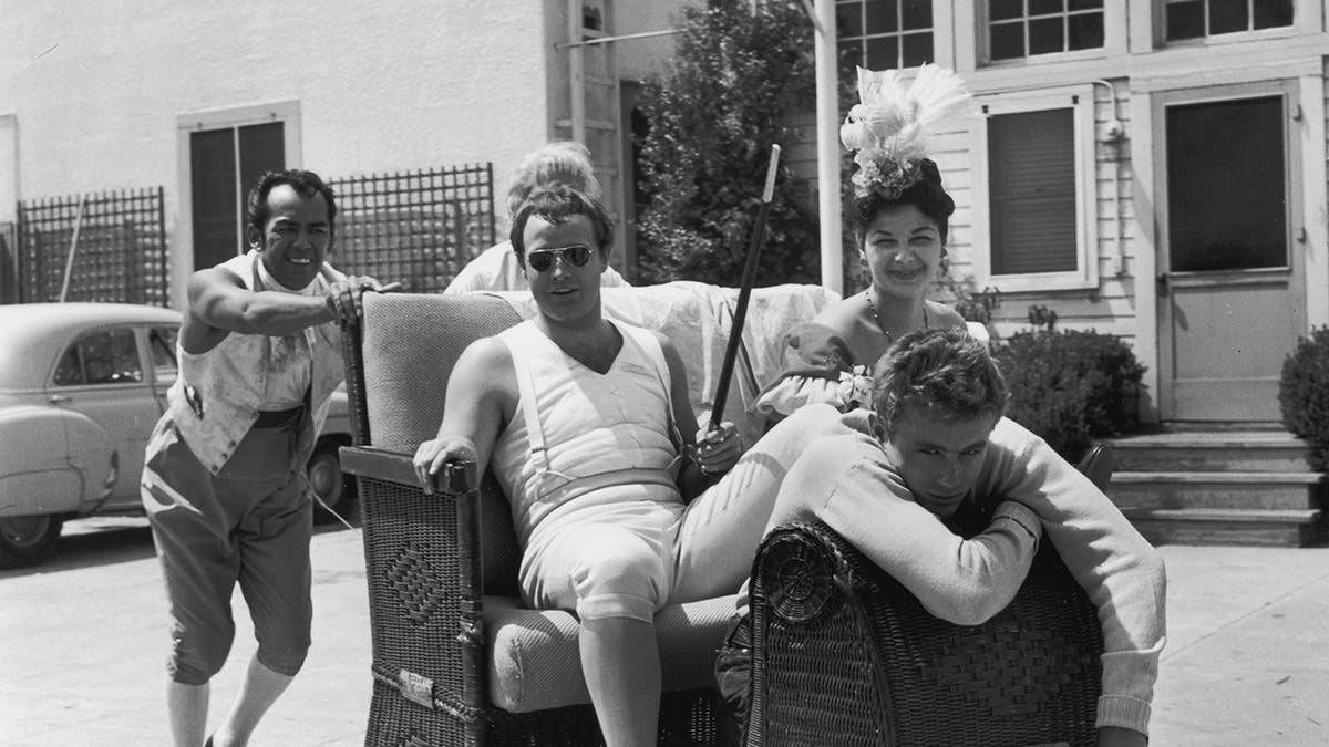 Um grupo de pessoas, incluindo Marlon Brando e James Dean, posando juntos para uma foto