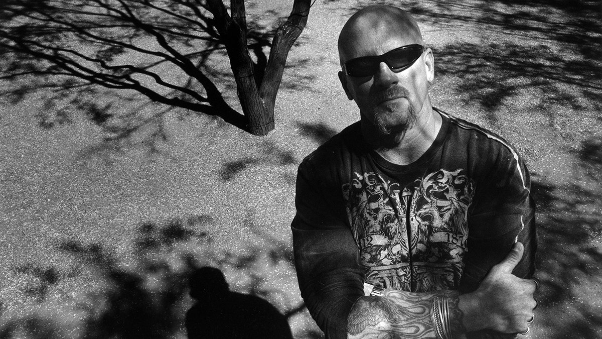 Jay Dobyns in black/white photo standing in front of a tree