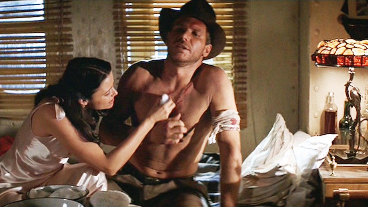 Karen Allen attending to Harrison Fords wound as Indiana Jones