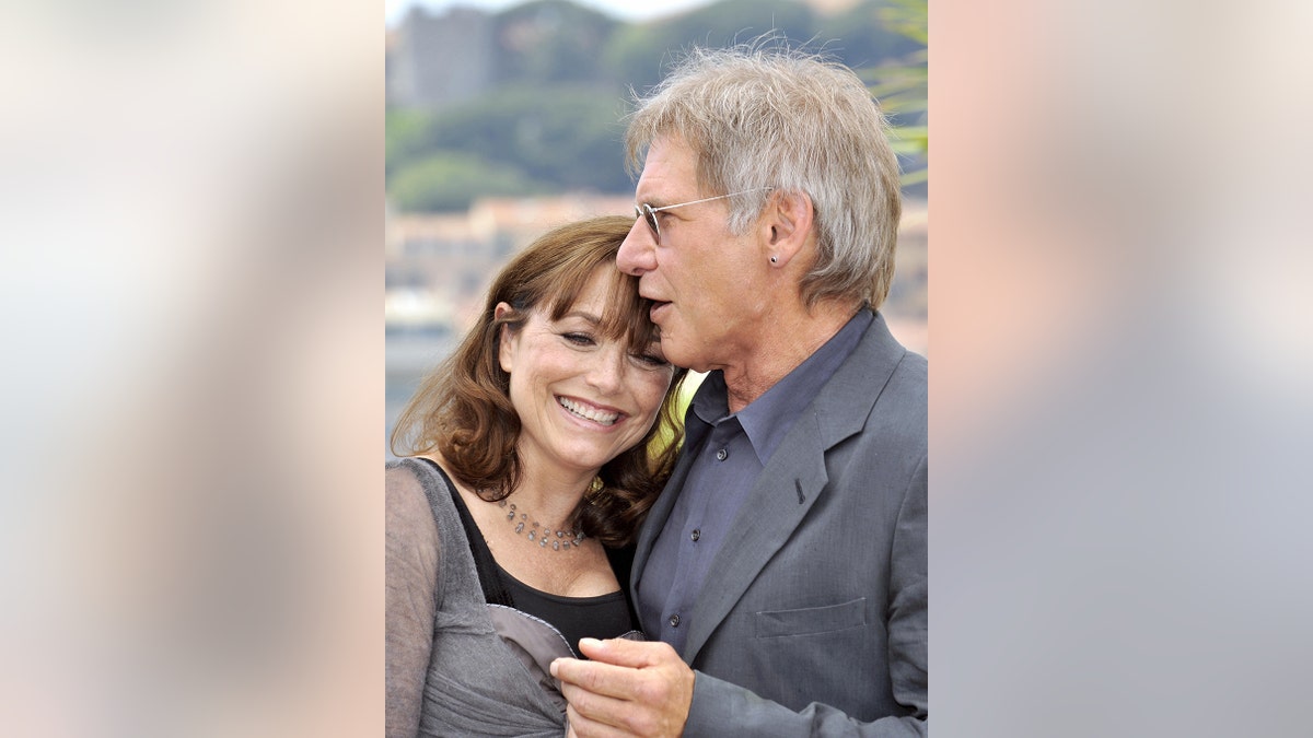 Karen Allen being embraced by Harrison Ford
