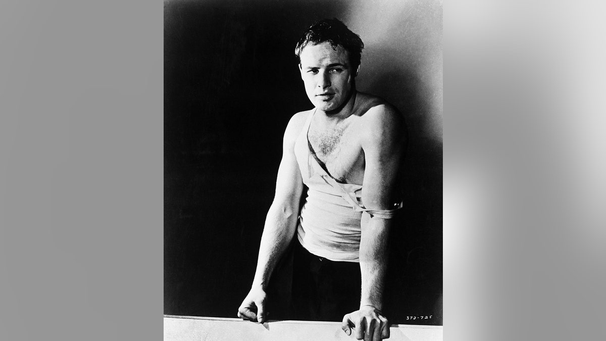 Marlon Brando posing in a ripped white tank top