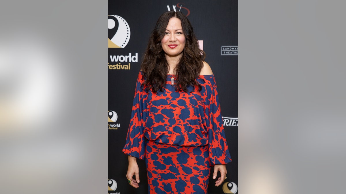 Shannon Lee wearing a blue and orange dress