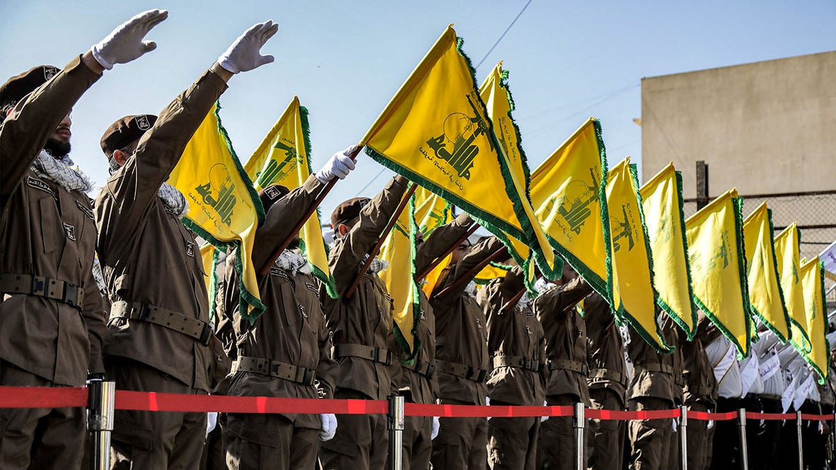 Hezbollah members salute at funeral