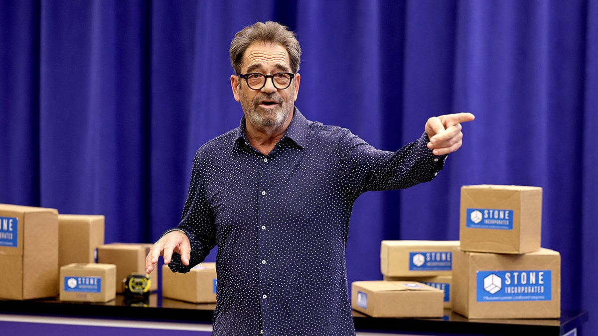 Huey Lewis standing in front of props from his Broadway show