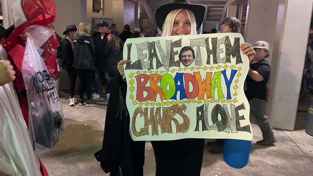 fan smiling and holding sign at morgan wallens concert