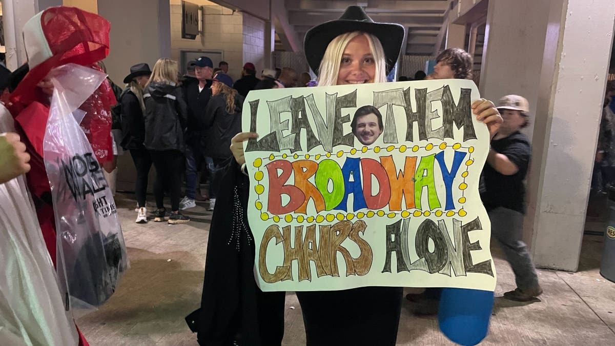 fan smiling and holding sign at morgan wallens concert