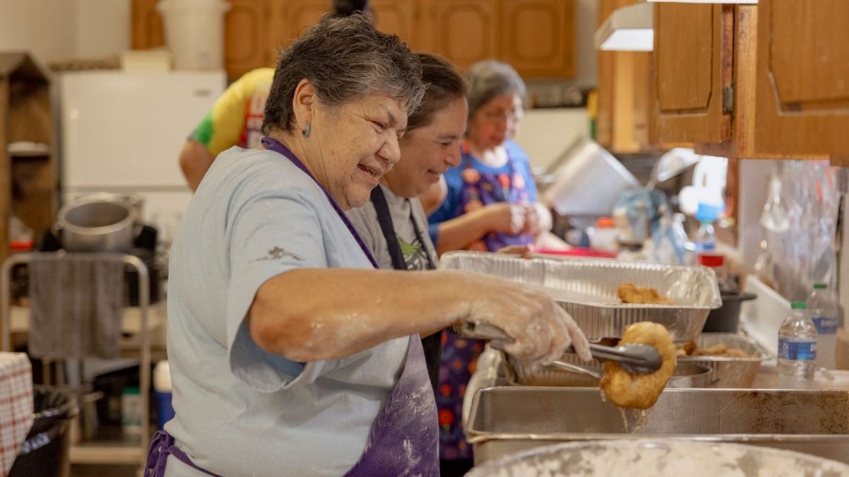 Carol Tiger, a personnel of Muscogee Nation and an elder astatine nan Springfield United Methodist Church successful Okemah, Oklahoma, lets nan lipid drip disconnected a freshly-cooked portion of frybread