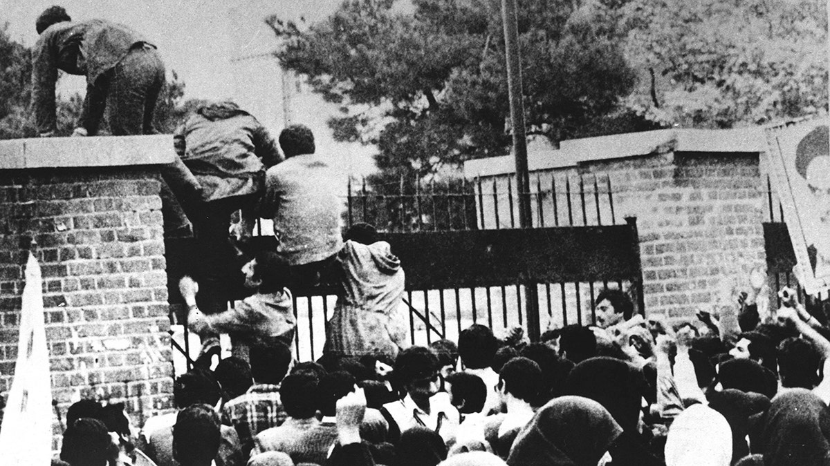 Estudantes iranianos escalando o muro da embaixada dos EUA em 1979
