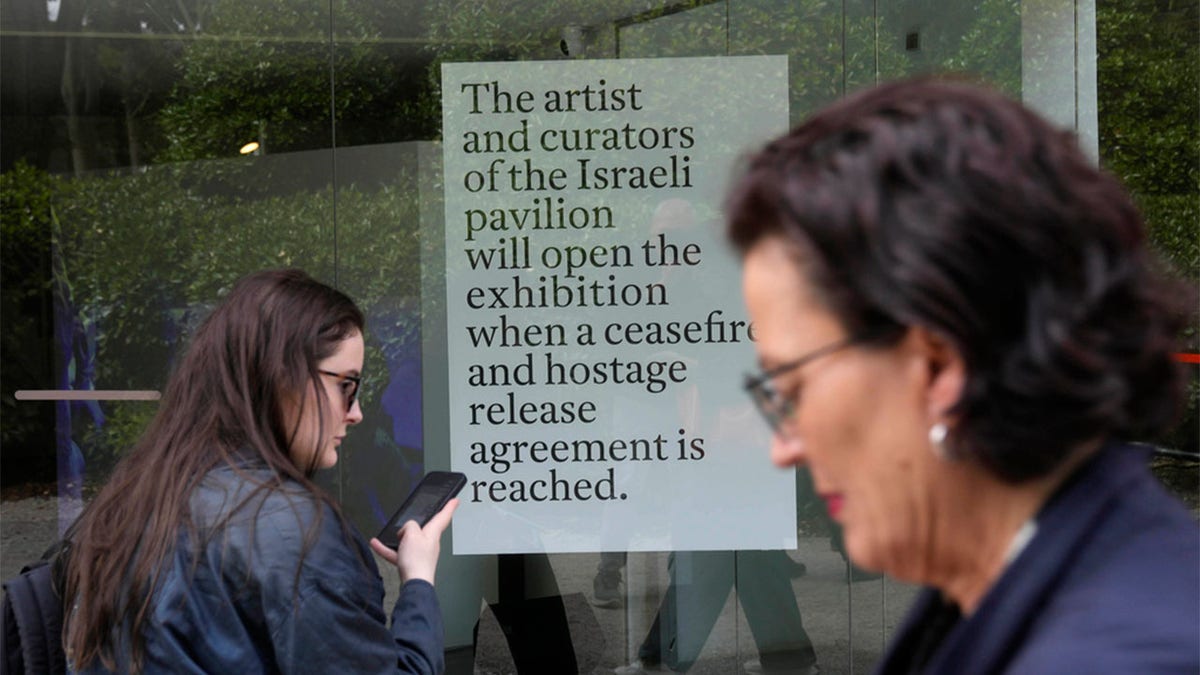 People walk past the Israeli National Pavilion at the Biennale