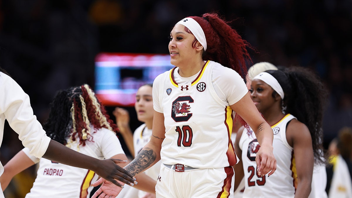 Kamilla Cardoso high fives with teammates