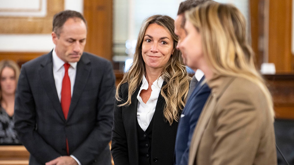 Karen Read stands with lawyers in court during jury selection at Norfolk County Superior Court