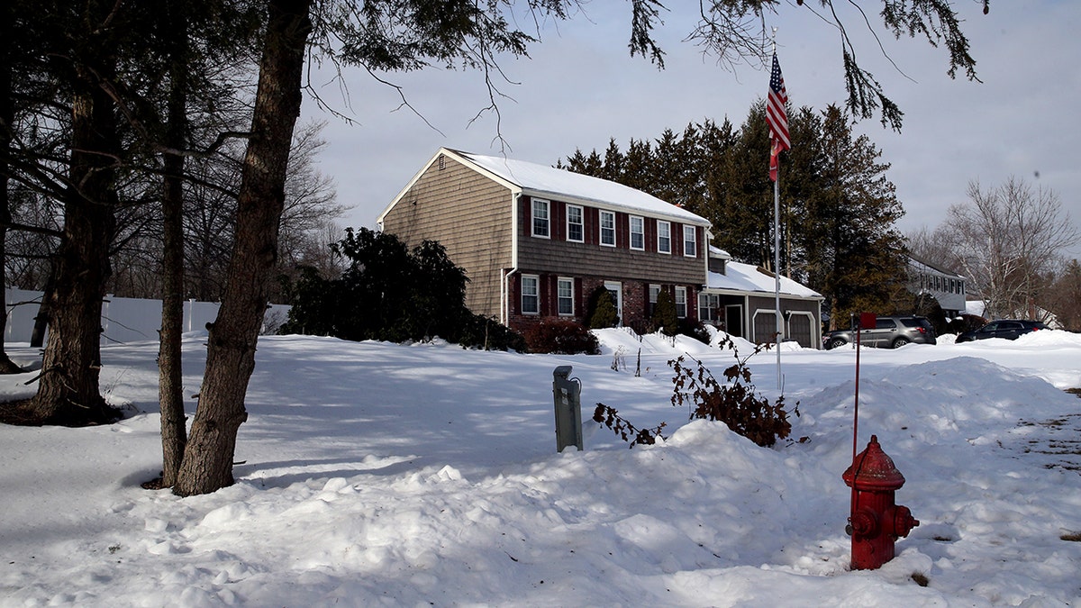 Two-story colonial house in the snow.