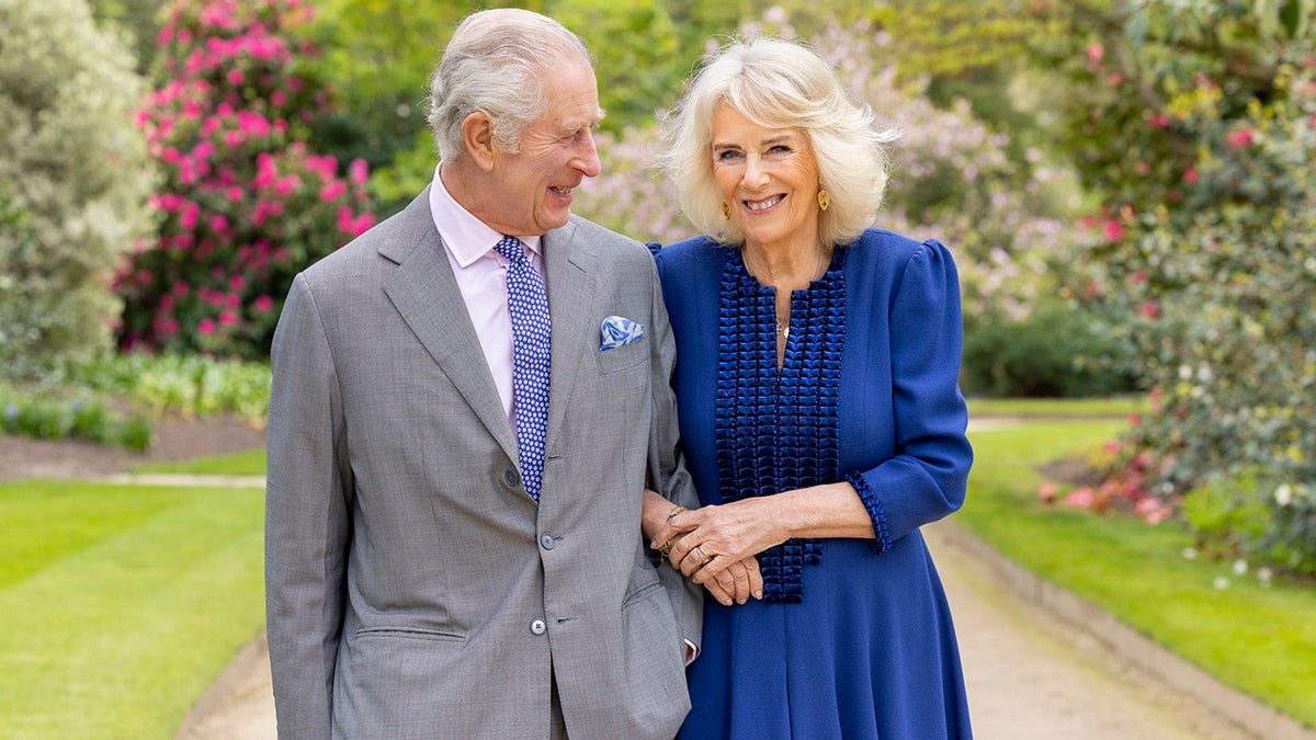 Britain's King Charles III and Queen Camilla stand in Buckingham Palace Gardens