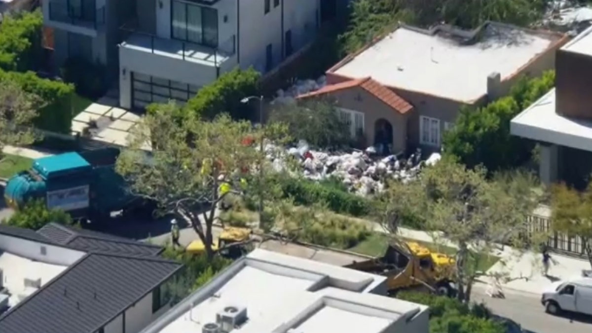 aerial view of LA home with piles of trash on front lawn