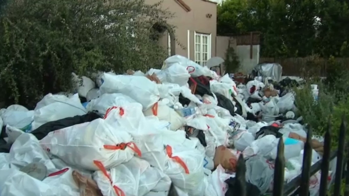 piles of filled trash bags outside home