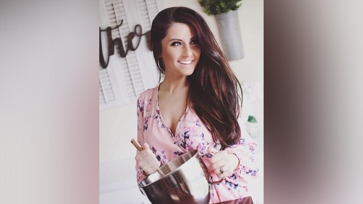 Cassie Tingley poses with a mixing bowl as she bakes a cake for her small business, Love and Flour.