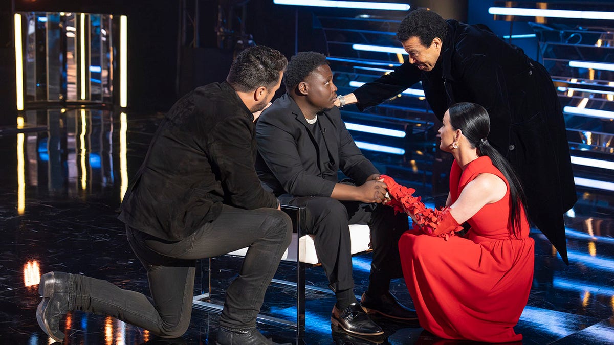 Luke Bryan, Lionel Richie e Katy Perry confortando um concorrente do American Idol