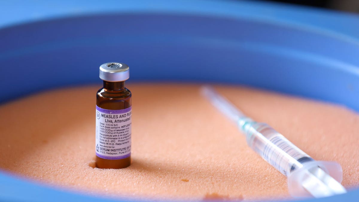 A vial containing the measles-rubella vaccine is sitting on top of an ice pack