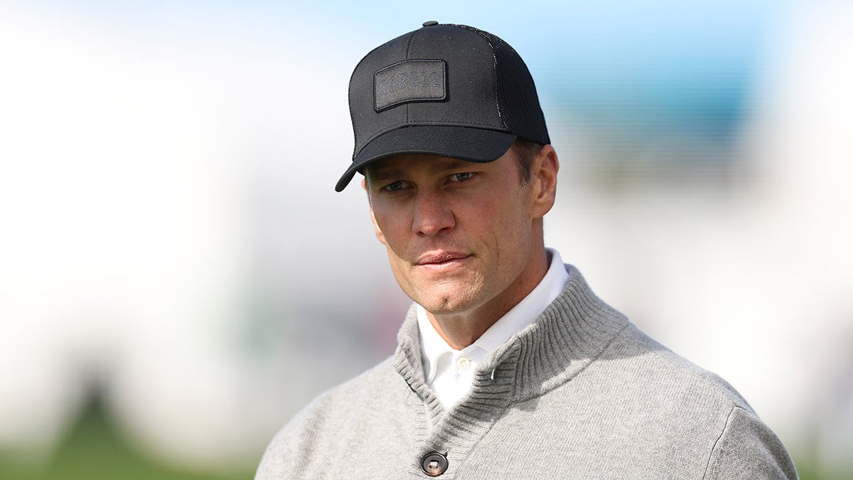 Tom Brady looks on at a golf tournment