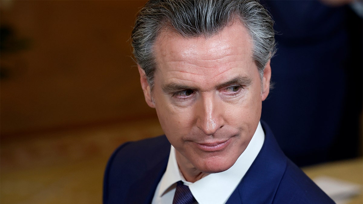 Newsom looking disconnected  to the side.