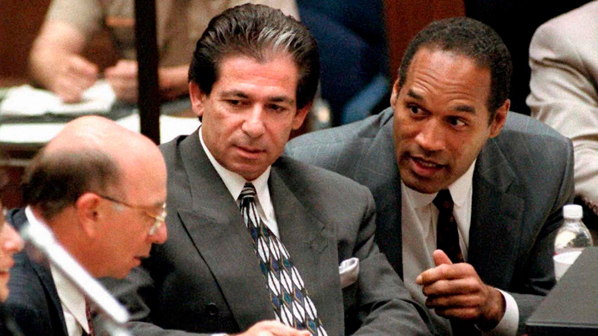 O.J. Simpson consults his attorneys during his trial.