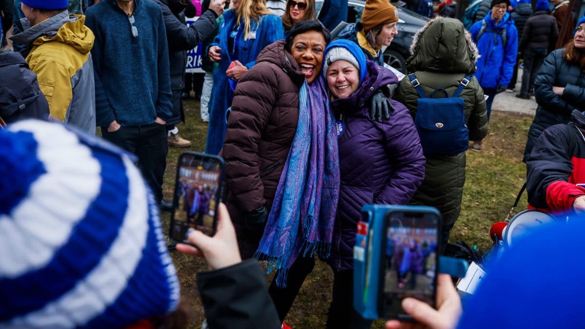 FILE - January 31: National Education Association President Becky Pringle takes photos with Newton Public School educators as they rally together on the lawn of Newton's Education Center, marking the ninth day of their strike. The union incurred a $50,000-per-day court-imposed fine for not calling off the strike, which is illegal under state law. (Photo by Erin Clark/The Boston Globe via Getty Images)