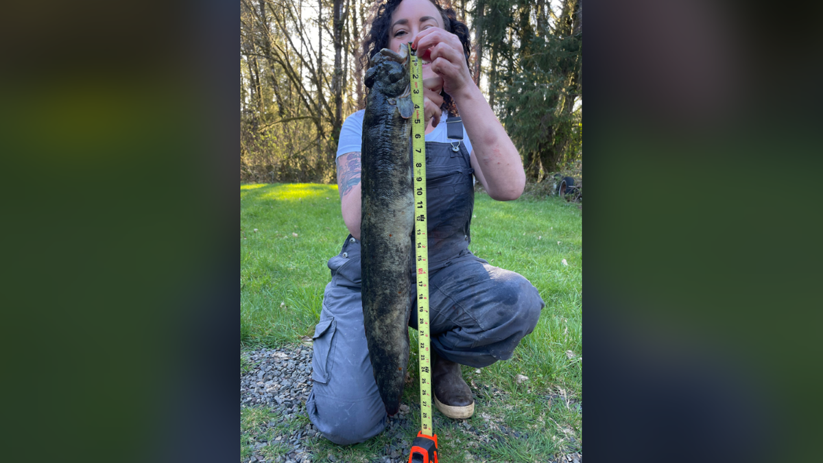 Jones holding measuring tape next to fish