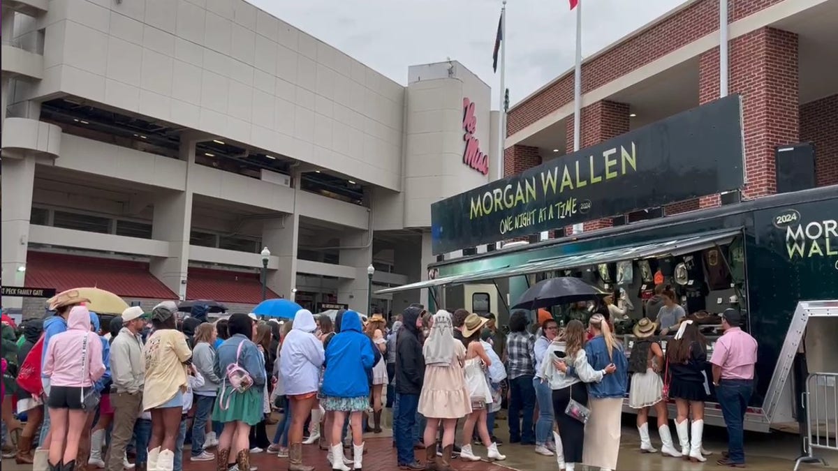 fãs fazem fila na chuva para entrar no estádio no show do Morgan Wallen