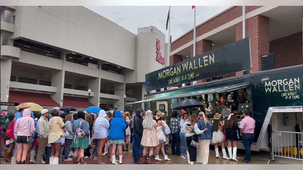 fans line up in the rain to enter the stadiun at the morgan wallen concert