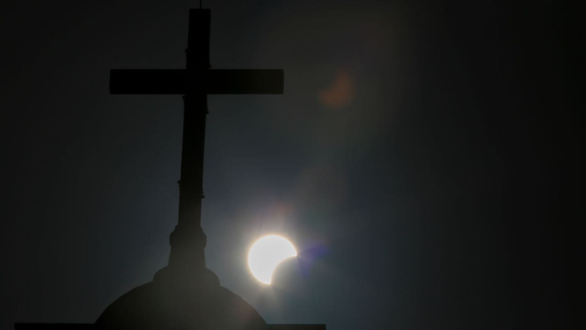 A partial star eclipse is seen down a cross
