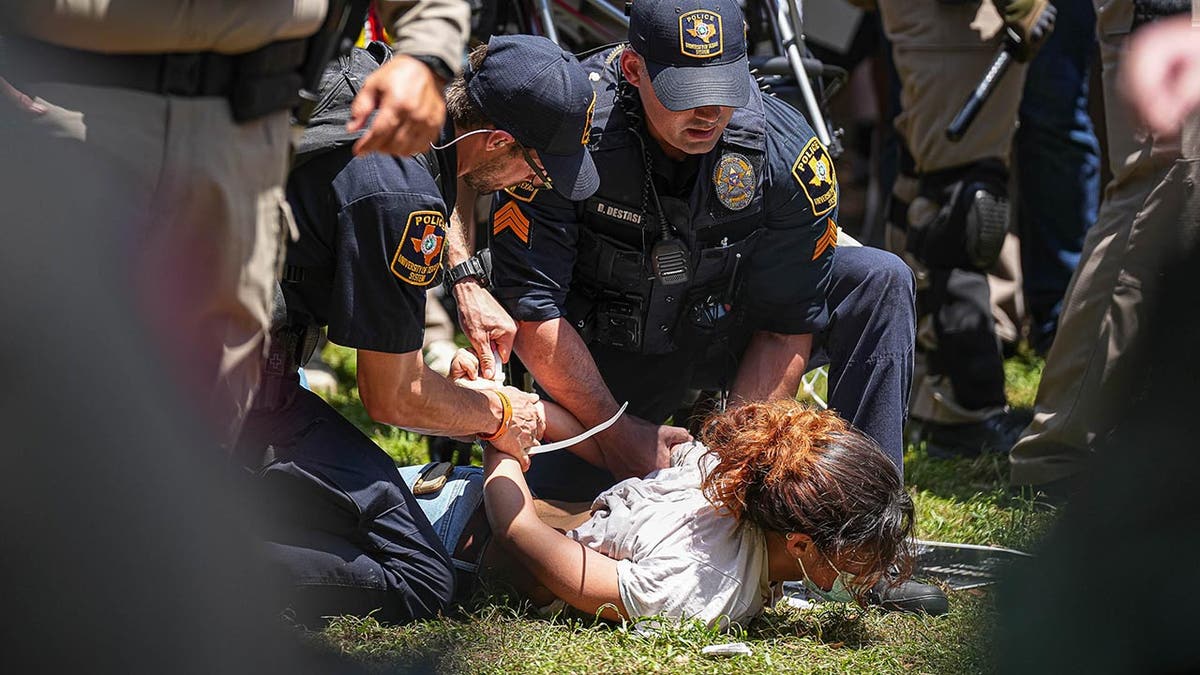 Police zip necktie a protester who is face-down connected nan ground