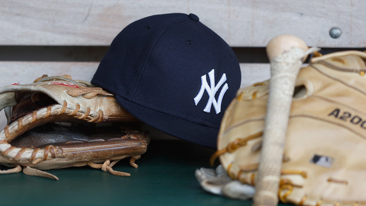 Yankees hat surrounded by gloves and bat