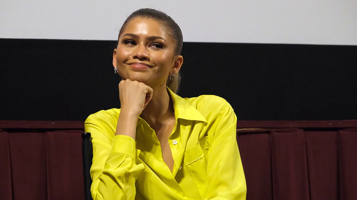 Zendaya smiling resting her chin connected her hand