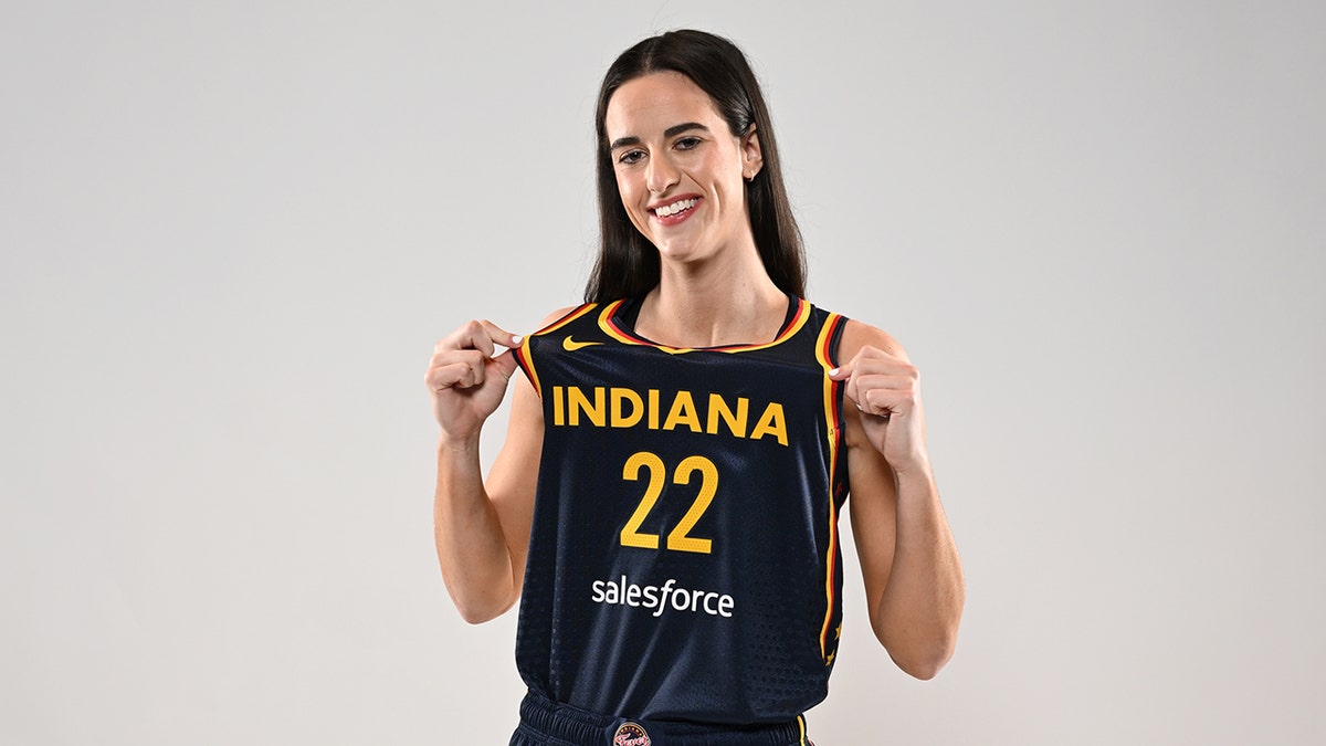 Caitlin Clark poses with Fever jersey