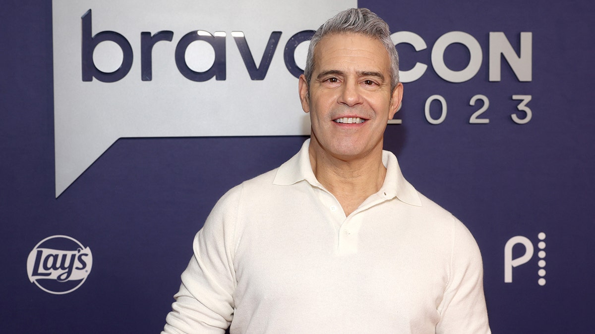 Andy Cohen em uma camisa branca sorri na BravoCon 2023