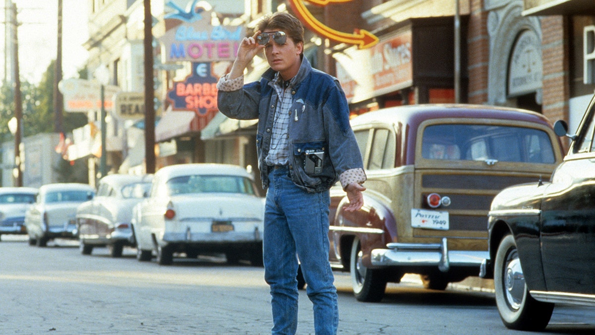 Michael J. Fox in a jean jacket and jeans filming a scene from "Back to the Future"