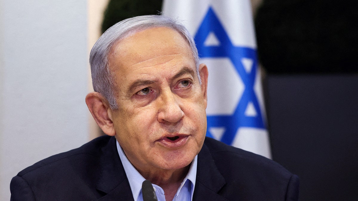 Benjamin Netanyahu in front of the flag of Israel 