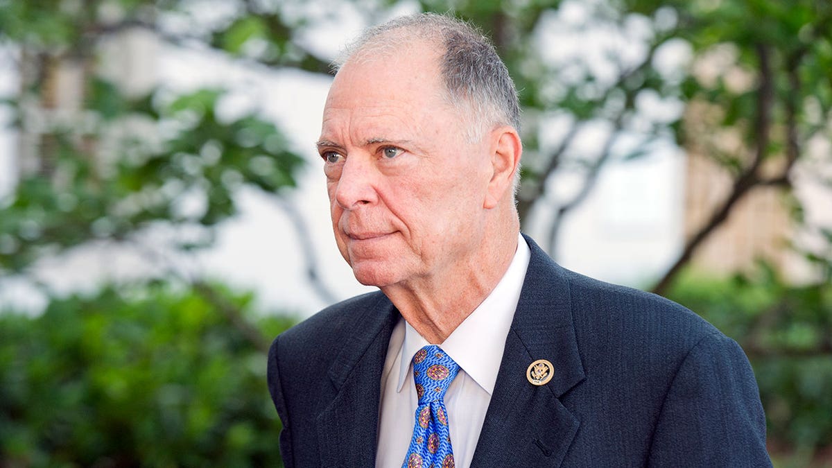 Rep. Bill Posey wears suit   and bluish  necktie  outside.