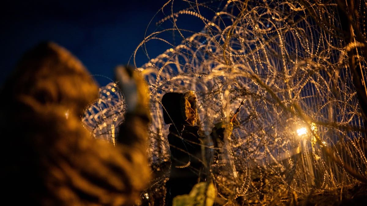 Migrants cut through border wire