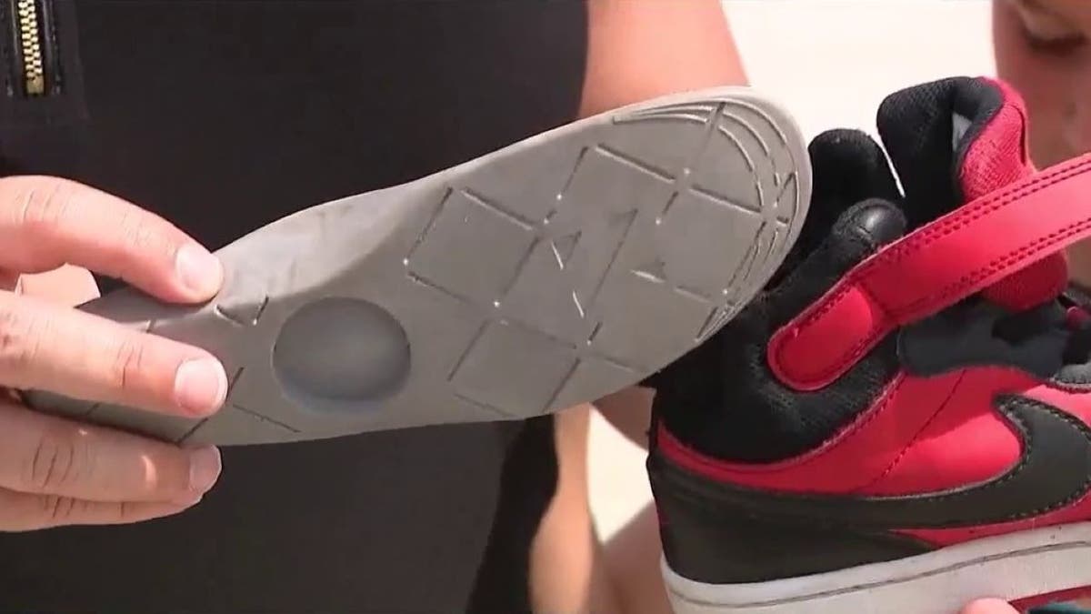 جیکی گیورلیو اپنے بیٹے کے جوتے میں ٹوکری دکھا رہا ہے۔