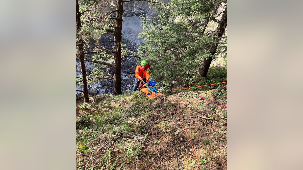 rescuer rappels down slope