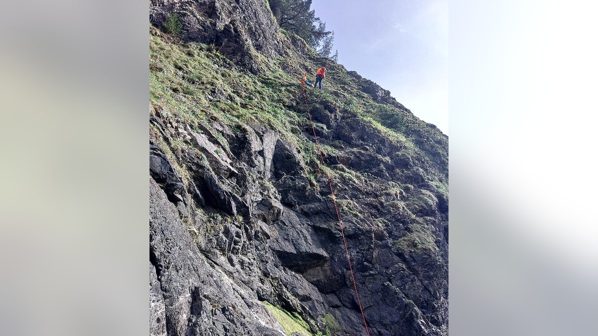 search and rescuer connected steep and rocky slope