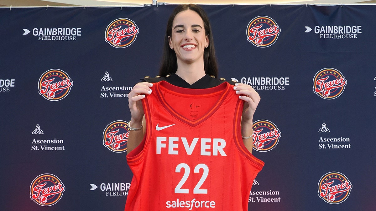 Caitlin Clark poses with jersey