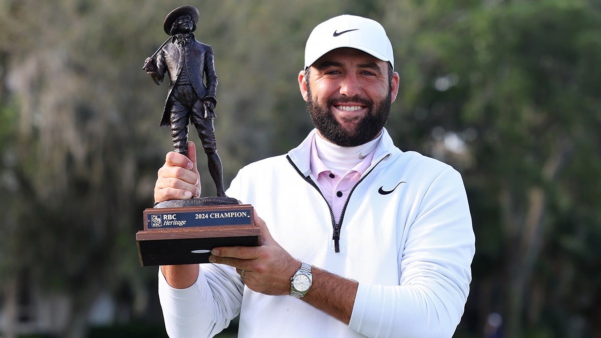 Scottie Scheffler poses with trophy