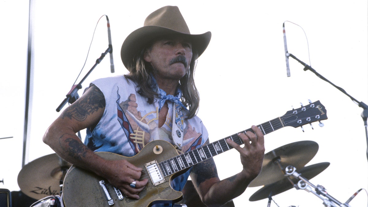 Dickey Betts in a white t-shirt and tan cowboy hat performs with the Allman Brothers Band in 1993