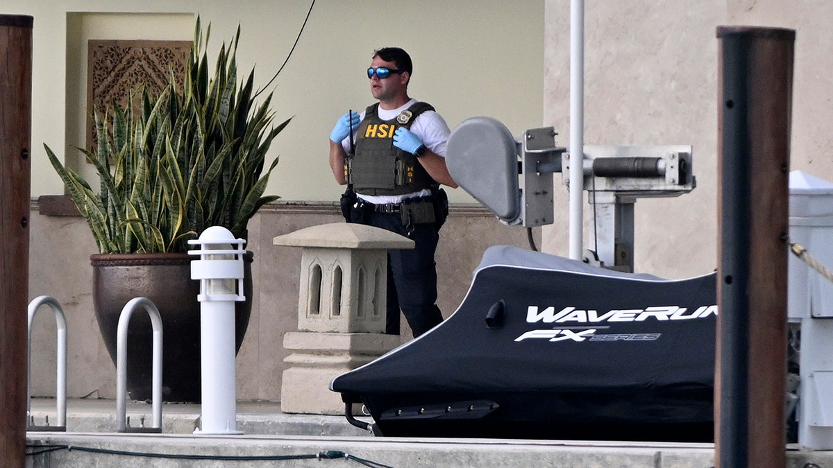 A cop stands on Diddy's boardwalk and looks serious