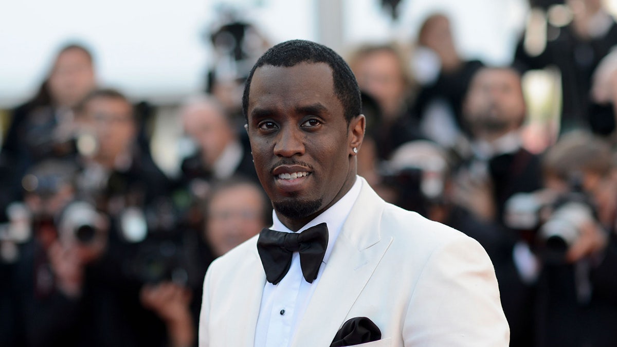 Sean Diddy Combs wears white suit with black bow tie