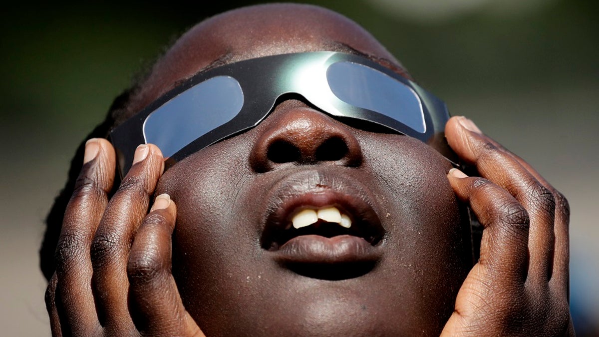 Someone with glasses watching a solar eclipse